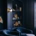 Shepherd's Run in South Kingstown lounge with dark blue paneled walls, arched shelving, and navy armchairs