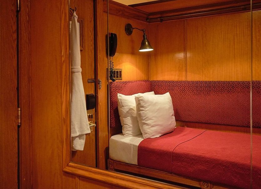West Village Eurohostel, New York: cozy wood-paneled bunk-style sleeping berth with red bedding and wall lamp