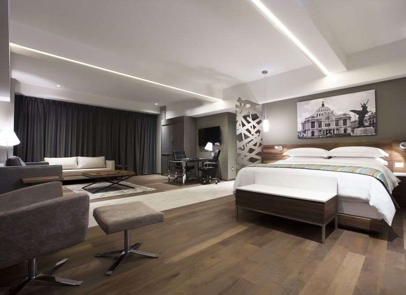 Krystal Grand Suites Insurgentes in Mexico City with a modern suite, king bed, seating area and floor-to-ceiling curtains