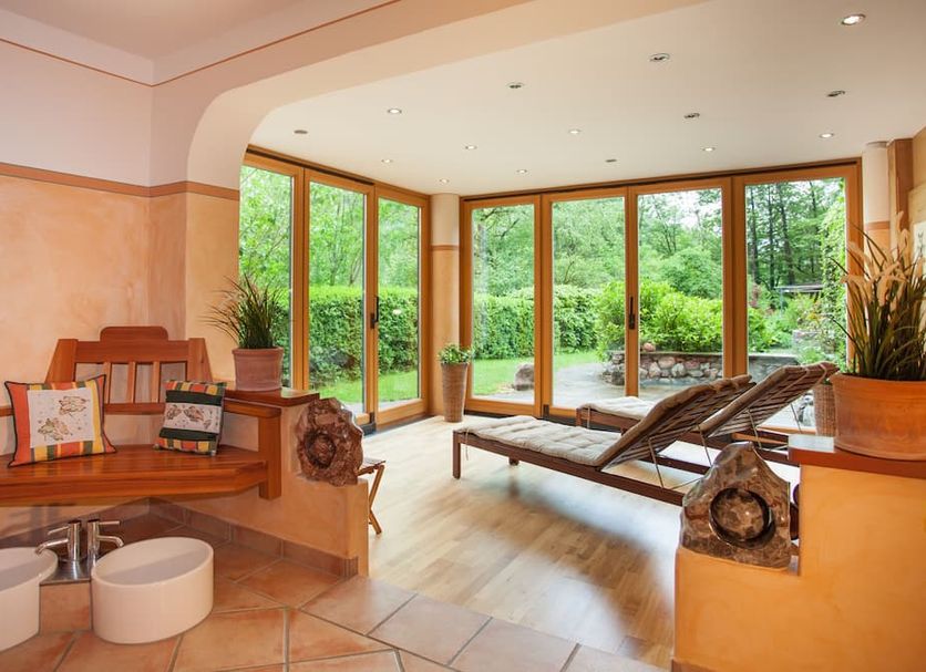 Hotel Pass Lueg spa lounge with loungers and floor-to-ceiling garden views in Golling an der Salzach