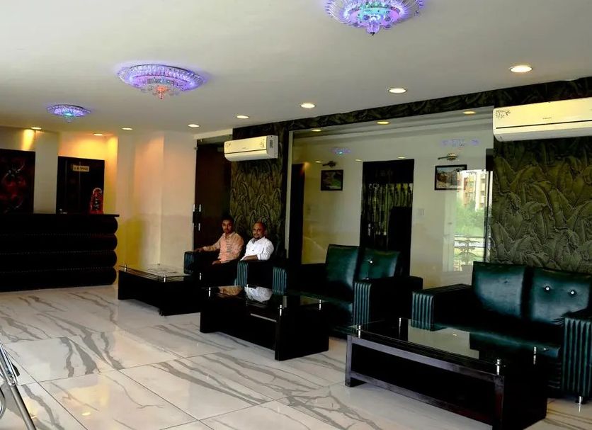 Hotel The Great Ananda Haridwar lobby with seating area, glossy marble floor, and decorative ceiling lights