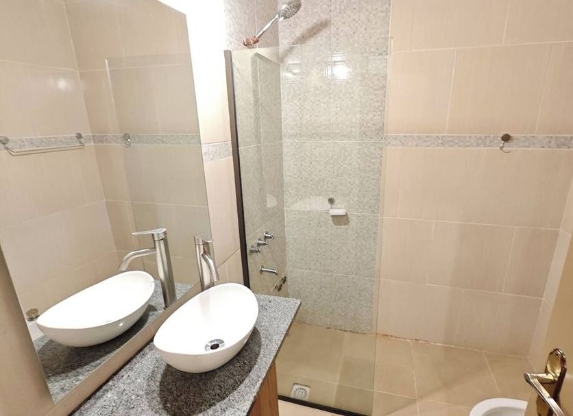 Hotel Tierra Colorada bathroom with double vessel sinks and glass-enclosed shower in Puerto Iguazú