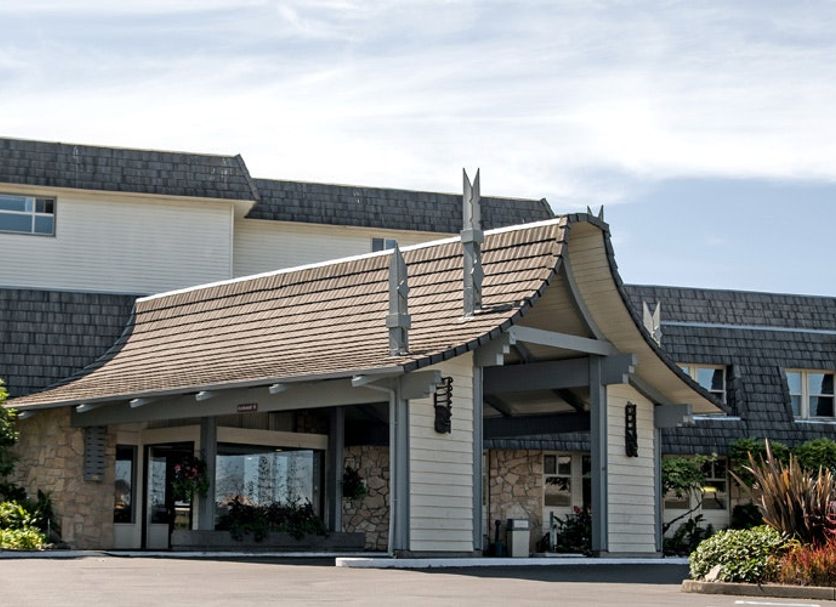 The Polynesian Resort in Ocean Shores with a covered entrance and landscaped front exterior