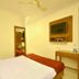 Hotel Golden Inn Chandigarh guest room with bed, wall-mounted TV, desk, and wardrobe