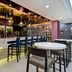 Hampton Inn New York-JFK in Queens lobby bar with high-top stools and round tables