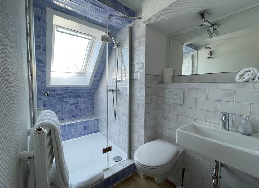Haus Hohensee, Clausthal-Zellerfeld: modern bathroom with glass shower, wall-hung sink and skylight