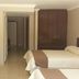 Hotel Graham Villahermosa guest room with two beds, desk, wall-mounted TV and wardrobe