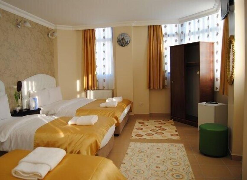 Lotus Hotel Istanbul triple room with three single beds, windows, wardrobe and patterned rugs