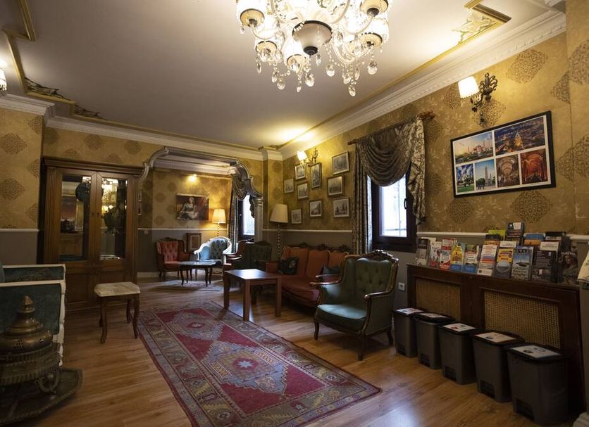 Tashkonak Hotel in Istanbul lounge with chandelier, patterned rug, armchairs and framed wall art