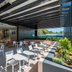 Outdoor terrace at Haberfield Hotel in Sydney with tables, chairs and garden planter beside a covered walkway.