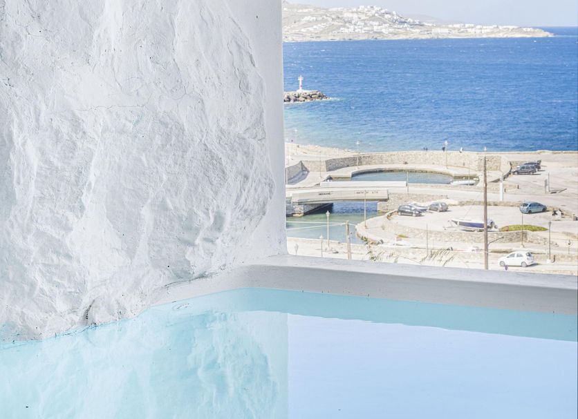 Tagoo Black Mykonos in Mykonos with cave-style pool and sea view through arched opening