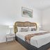 Metzo Noosa Resort bedroom in Noosa Heads with a king bed, bedside lamps, and coastal artwork