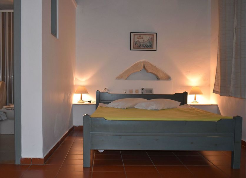 Vecchio Hotel in Rethymno bedroom with double bed, bedside lamps, and tiled floor