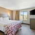 Red Roof Inn & Suites Fayetteville-Fort Bragg room with king bed, window view, and wall-mounted TV