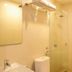 Vio Hotel Cimanuk Bandung bathroom with sink, toilet, mirror, and glass shower in Bandung