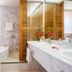 Hôtel Colbert Palace bathroom in Antananarivo with marble tub, double sink vanity and wood shower enclosure