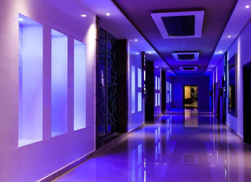 Sky Casa Airport, Nouaseur: modern purple-lit hotel hallway with glossy floor and wall panels