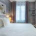 Makom Pereire in Paris guest room with bed, window, and tiled walk-in shower