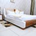 Golden Zambezi Lodge Lusaka guest room with white bed, floral rugs and large window