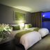 Aventree Hotel Busan guest room with two beds and a city view through the window
