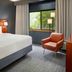 Courtyard by Marriott Nashville Brentwood guest room with king bed, orange chair and window view in Brentwood