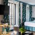 Hôtel Aoriste & Spa Paris guest room with bed, balcony doors, and teal patterned curtains