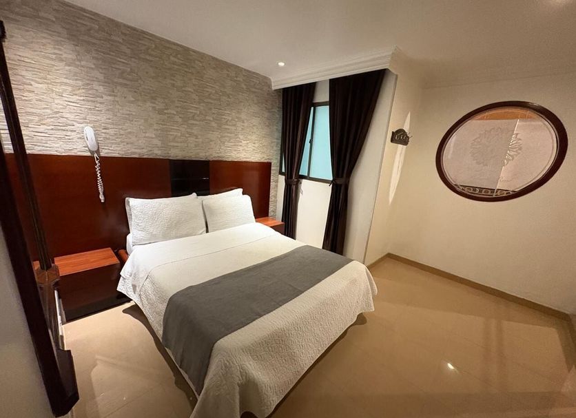 Lavid Hotel Palacio Real in Bogotá, guest room with double bed, bedside lamps and window curtains.