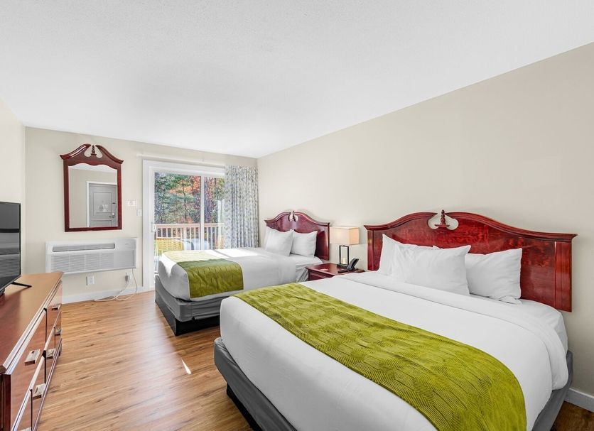 Grey Bonnet Inn in Killington guest room with two beds, TV, window view, and wood furniture