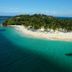 Aerial view of The Bannister Hotel in Samaná near a tropical island with white-sand beach and turquoise water