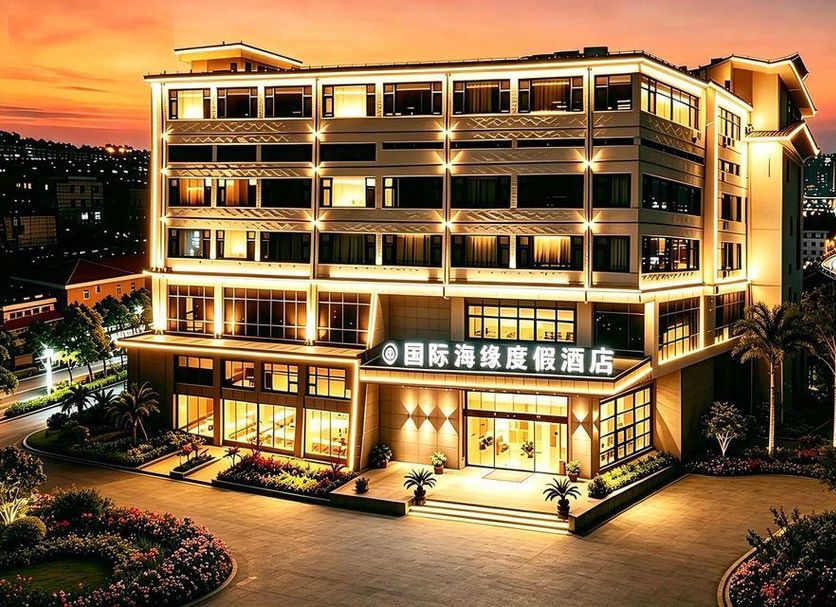 International Haiyuan Resort Hotel in Nantong at dusk, with illuminated facade and city skyline beyond
