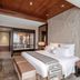 Grand Pacific Hotel Ningbo guest room with king bed, bench, wood ceiling and marble bathroom view in Ningbo