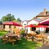 Premier Inn Northampton South - Wootton in Northampton with outdoor picnic tables and red umbrellas on a lawn