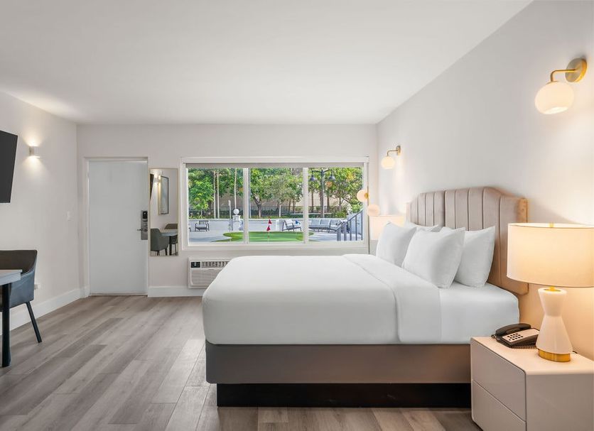The Garden Hotel & Resort, Fort Lauderdale guest room with king bed, desk, and pool view