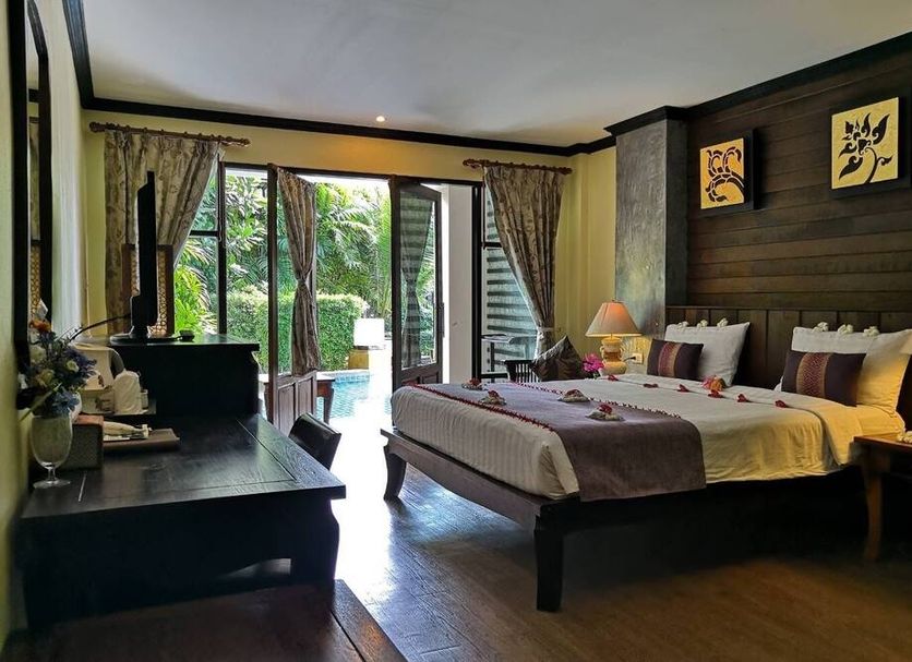 Seashell Resort Hostel Koh Tao bedroom with king bed, seating area, and balcony garden view in Ko Tao