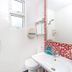 Hotel 81 Kovan bathroom in Singapore with shower, toilet, sink and red mosaic tile accent