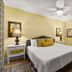 Emerald Beach Resort Panama City Beach guest room with king bed, mirrored closet and ceiling fan