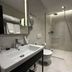 Mulaj Hotel in Tirana bathroom with walk-in shower, wall-mounted sink and toilet