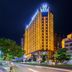 Marriott Hotel in Yunfu lit up at night on a city street with glowing golden facade