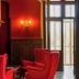 Domaine De Brou in Noyant-de-Touraine, elegant red lounge with armchairs and tall windows