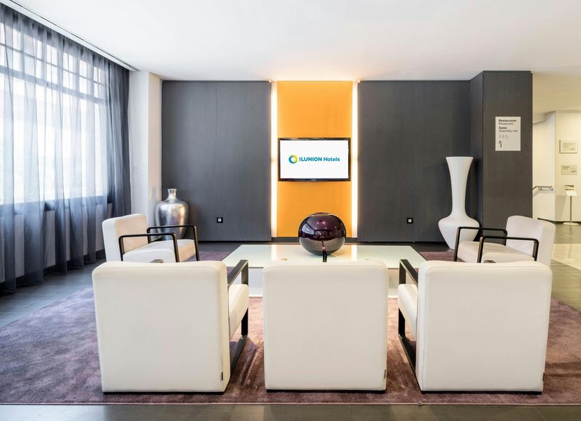 Hotel Ilunion Romareda lobby seating area in Zaragoza with modern white chairs and lounge decor
