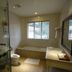 Fontana Hot Spring Leisure Parks bathroom with soaking tub, glass shower, vanity, and window view in Angeles City