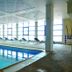Vila Gale Porto indoor pool with lounge chairs and large windows overlooking Porto
