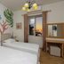 Le Palazzine Hotel in Vlorë room with twin beds, tropical mural, and sunset sea view