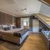 Landgoed De Uitkijk Hellendoorn room with king bed, sloped ceiling, and freestanding bathtub
