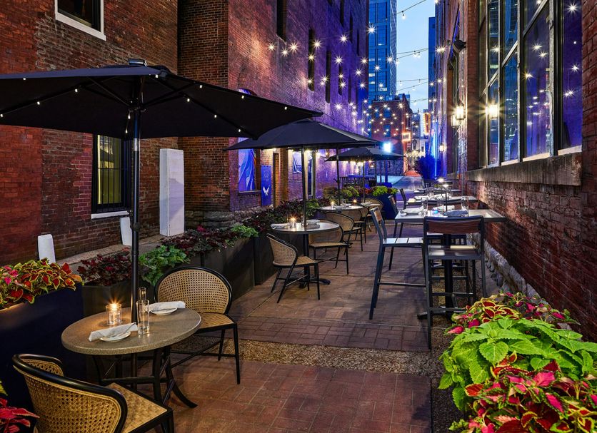 The Bankers Alley Hotel Nashville patio seating with string lights and city alley view in Nashville