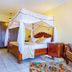 Rainbow Ruiru Resort in Nairobi: four-poster bed in a tiled hotel room with seating area