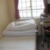 Matsuyama Youth Hostel room with single bed, desk, chair and window in Matsuyama