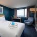 Travelodge London Kingston Upon Thames room with king bed, desk, window sea view and armchair in Kingston upon Thames