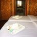 Mari Pai Resort in Pai room with twin beds, folded towels, and a bathroom visible through doorway
