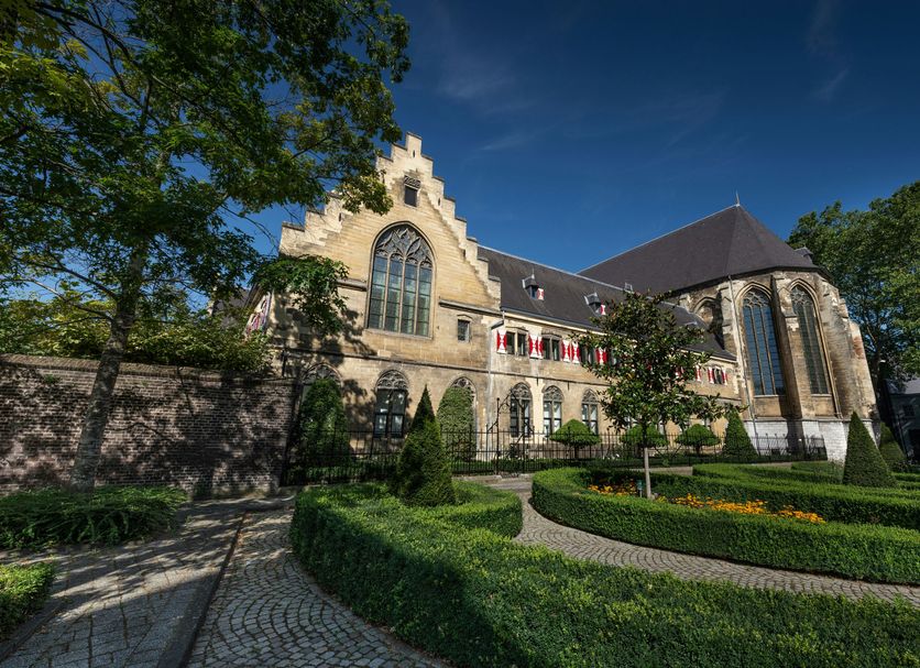 Kruisherenhotel Maastricht, Maastricht: historic stone hotel exterior with manicured garden and arched windows